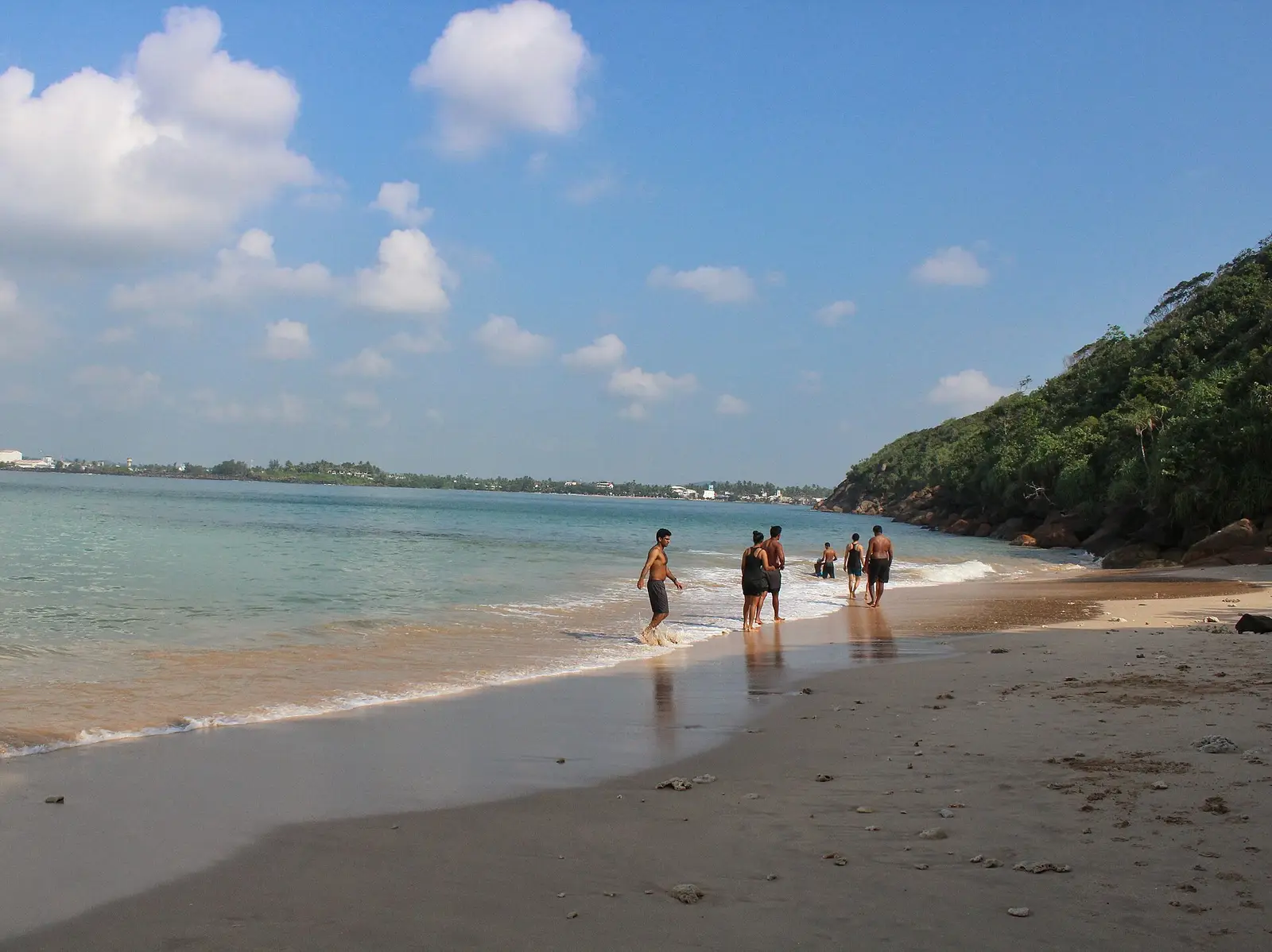 People on the sheltered sandy bay at Unawatuna