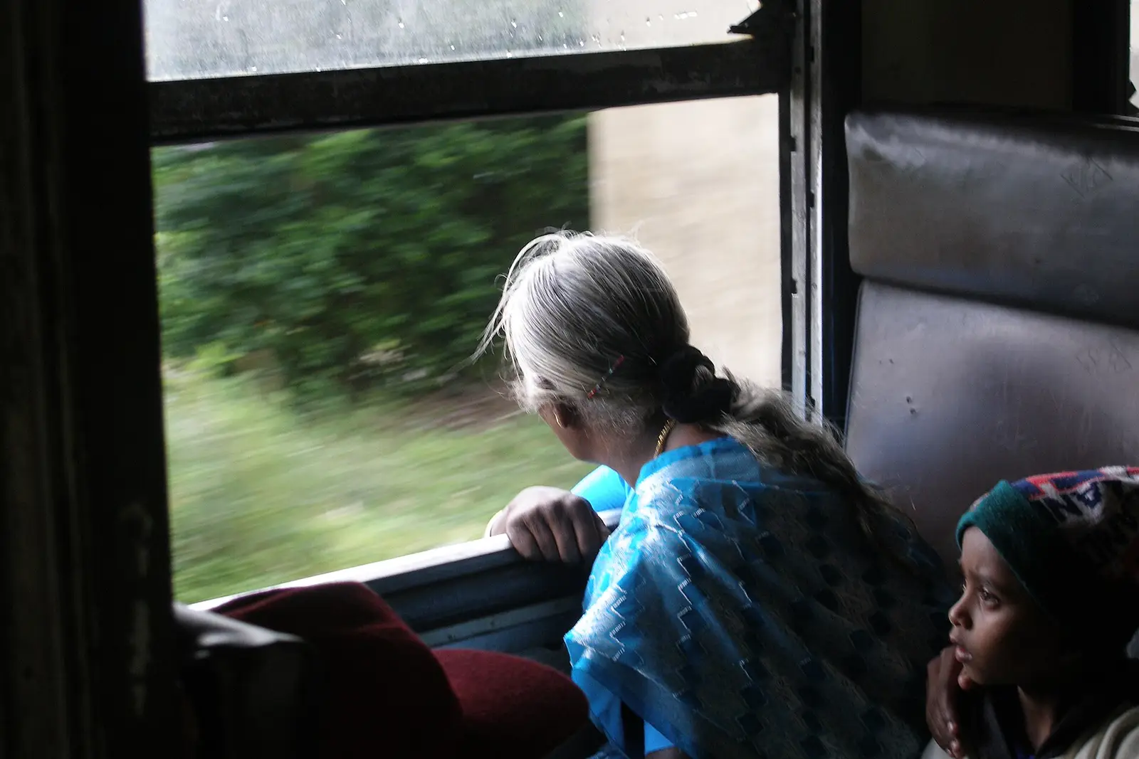 Passenger looking out of a train window in the hill country
